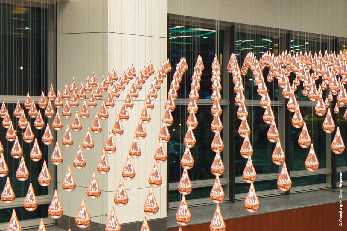 "雨之舞 "是新加坡樟宜机场的一座动态雕塑，该作品使用了 1216 滴闪闪发亮的镀铜铝制雨滴造型。 © Changi Airport Group Singapore
