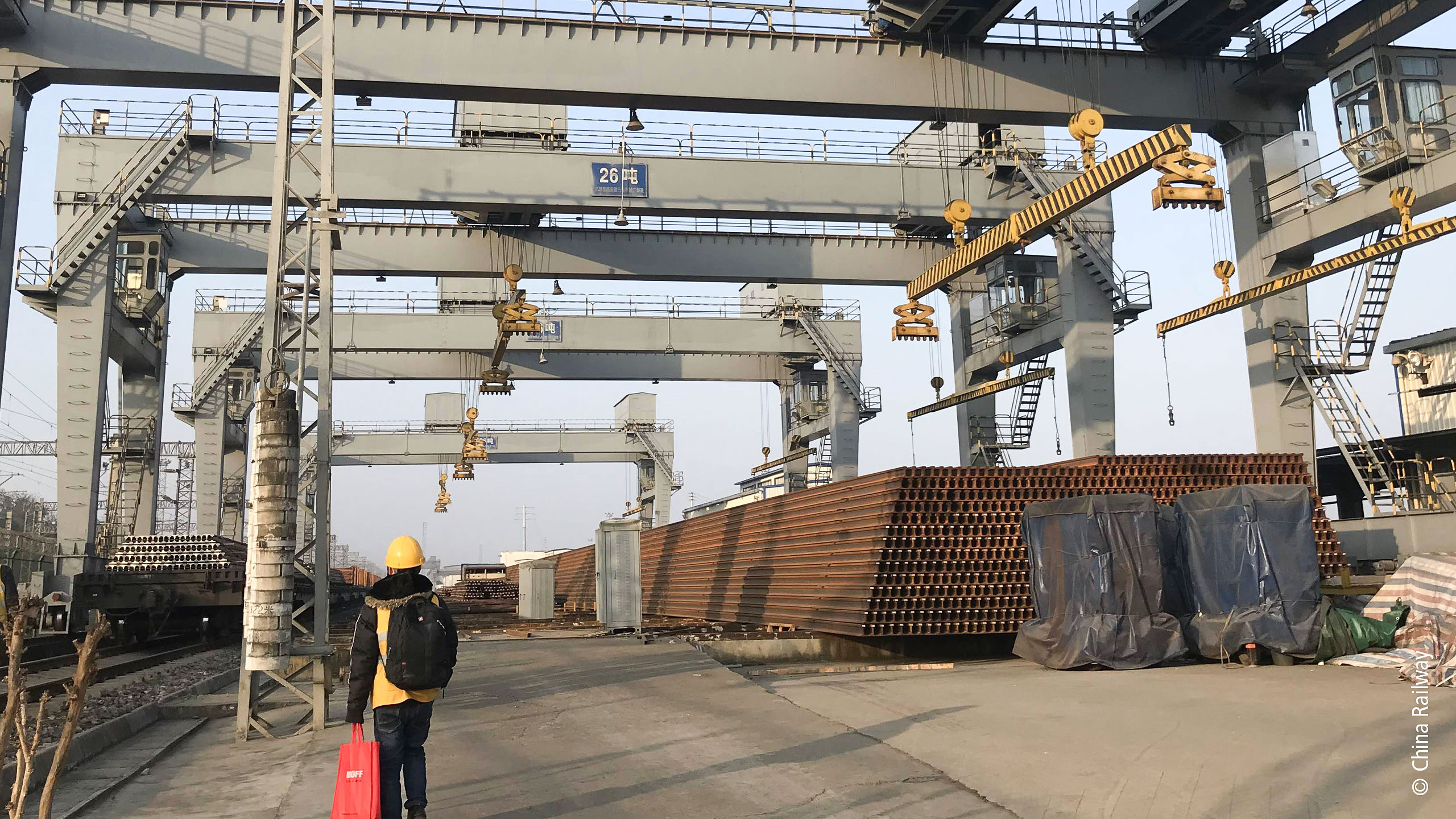 中国铁路总公司的串联式起重机吊装系统正在运送 100 米的铁轨。 