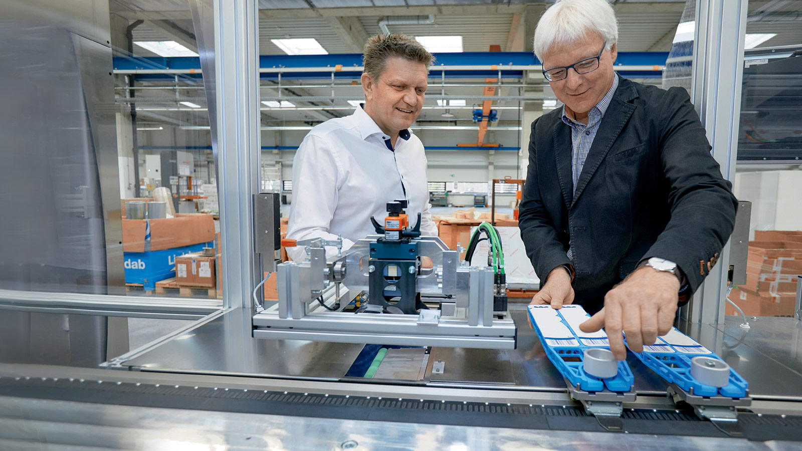 Koch Pac-Systeme 公司 Jürgen Welker（右）向倍福的 Frank Würthner 展示如何轻松地切断泡罩托架快速实现产品切换 